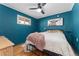 Cozy bedroom featuring teal-painted walls, a plush pink blanket, and a framed longhorn print above the bed at 511 S Pennsylvania St, Denver, CO 80209