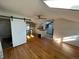 View of the living space and kitchenette with hardwood floors, skylights, and barn door at 511 S Pennsylvania St, Denver, CO 80209