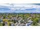 Stunning aerial view of a serene neighborhood nestled among lush trees, showcasing mountain views in the background at 13323 Birch Cir, Thornton, CO 80241
