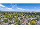 Picturesque aerial view of a tree-filled neighborhood with rooftops and distant mountains at 13323 Birch Cir, Thornton, CO 80241