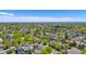 Spacious neighborhood with lush green trees, sidewalks, and a beautiful skyline in the distance at 13323 Birch Cir, Thornton, CO 80241