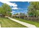 Fenced backyard with a grassy walking path that has mature trees along its left and right sides at 13323 Birch Cir, Thornton, CO 80241