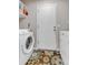 Functional laundry room is equipped with modern appliances, convenient shelving, and patterned flooring at 13323 Birch Cir, Thornton, CO 80241