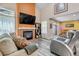 Cozy living room features a brick fireplace, soaring ceilings, and ample natural light for comfortable living at 13323 Birch Cir, Thornton, CO 80241