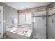 Bright bathroom features separate tub and shower with tile surround and a window at 8825 Fairview Oaks Pl, Lone Tree, CO 80124