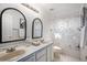 Bathroom with double sink vanity, tub-shower combo with patterned curtain, and decorative mirrors at 8825 Fairview Oaks Pl, Lone Tree, CO 80124