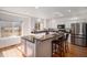 Open kitchen with granite counters, white cabinets, stainless appliances and island with seating at 8825 Fairview Oaks Pl, Lone Tree, CO 80124