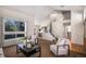 A welcoming living room showcases vaulted ceilings, a large window, and an adjacent staircase at 8825 Fairview Oaks Pl, Lone Tree, CO 80124