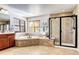 Bright bathroom showcasing a soaking tub and glass-enclosed shower with tiled surround at 6074 S Oswego St, Greenwood Village, CO 80111