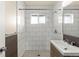 Bathroom with updated tile flooring, shower and vanity at 4211 E 69Th Ave, Commerce City, CO 80022