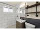 Updated bathroom with white subway tile, dark wood accents and floating wood shelves at 4211 E 69Th Ave, Commerce City, CO 80022