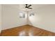 Cozy bedroom with hardwood floors, ceiling fan, and ample natural light from two windows at 4211 E 69Th Ave, Commerce City, CO 80022