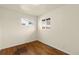 Empty bedroom with light walls, hardwood floors, and a bright window overlooking the exterior at 4211 E 69Th Ave, Commerce City, CO 80022
