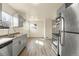 Renovated kitchen with stainless steel appliances, grey cabinetry, and stylish countertops at 4211 E 69Th Ave, Commerce City, CO 80022