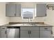 Bright kitchen with stainless steel dishwasher, new cabinets, and a large sink under the window at 4211 E 69Th Ave, Commerce City, CO 80022