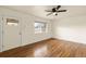 Well-lit living room with beautiful hardwood floors, a stylish front door, and large window at 4211 E 69Th Ave, Commerce City, CO 80022
