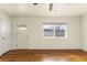 Inviting living room showcasing hardwood floors, a front door with window, and ample natural light at 4211 E 69Th Ave, Commerce City, CO 80022