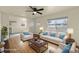 Staged living room with hardwood floors, bright windows, and comfortable seating arrangement at 4211 E 69Th Ave, Commerce City, CO 80022