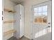 A modern mud room with built-in shelves and storage, adjacent to a well-lit exterior door at 4211 E 69Th Ave, Commerce City, CO 80022