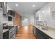 Modern kitchen featuring stainless steel appliances and hardware, exposed brick wall and pendant lighting at 1211 E 26Th Ave, Denver, CO 80205