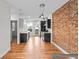 Modern kitchen featuring dark cabinetry, stainless steel appliances, and brick accent wall at 1211 E 26Th Ave, Denver, CO 80205