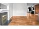 Open-concept living room with hardwood floors, featuring a fireplace and seamless flow to the modern kitchen at 1211 E 26Th Ave, Denver, CO 80205