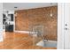 Open concept living area with exposed brick wall, hardwood floors, and stainless appliances at 1211 E 26Th Ave, Denver, CO 80205