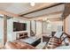 Finished basement with exposed beams, TV, and comfortable leather seating at 1557 North St, Boulder, CO 80304