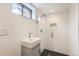 Modern bathroom with white tiled walls, black and white tiled floor, and glass shower at 1557 North St, Boulder, CO 80304
