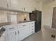 Open kitchen with wood-look counters, white cabinets, and view to a bright living room at 56 S Nome St, Aurora, CO 80012