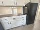 Open kitchen with wood-look counters, white cabinets, and view to a bright living room at 56 S Nome St, Aurora, CO 80012