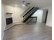 Bright living room features modern floors, a fireplace, and an adjacent stairway to upper level at 56 S Nome St, Aurora, CO 80012