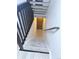 View of carpeted staircase with dark wood railing leading down to a doorway and landing area at 56 S Nome St, Aurora, CO 80012
