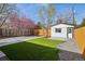 Backyard featuring green lawn, gravel and walkway leading to the detached garage at 1209 Harrison St, Denver, CO 80206