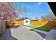 Fenced backyard with mature tree, gravel and walkway leading to the detached garage at 1209 Harrison St, Denver, CO 80206