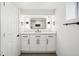 Bright bathroom with vanity, a framed mirror, modern fixtures, and white cabinets at 1209 Harrison St, Denver, CO 80206