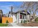 Charming white brick home with a red front door and a well-manicured front yard, enhancing curb appeal at 1209 Harrison St, Denver, CO 80206