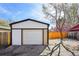 Detached one-car garage with white door and trim, adjacent to a gravel area and wood fence at 1209 Harrison St, Denver, CO 80206