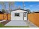 Detached one-car garage with gray patio, white siding, and wood fence at 1209 Harrison St, Denver, CO 80206