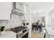 Modern kitchen with stainless steel appliances and stylish backsplash, open to the dining and living areas at 1209 Harrison St, Denver, CO 80206