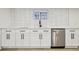 Modern wet bar featuring a sink, stainless steel dishwasher, and bright, white subway tile at 1209 Harrison St, Denver, CO 80206