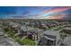 Aerial view of a neighborhood showcasing multiple houses, landscaping, and vibrant sunset at 3453 Pacific Peak Dr, Broomfield, CO 80023