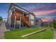 Exterior view of a multi-story home with a spacious backyard, a wooden deck and stairs, and beautiful landscaping at 3453 Pacific Peak Dr, Broomfield, CO 80023