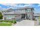 Attractive two-story home with stone accents, gray siding, and a large garage, set on a well-maintained lawn at 3453 Pacific Peak Dr, Broomfield, CO 80023