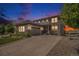 Beautiful two-story home with stone accents, gray siding, and a spacious driveway at twilight at 3453 Pacific Peak Dr, Broomfield, CO 80023