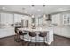Bright kitchen with white cabinets, stainless steel appliances, large island with seating, and pendant lighting at 3453 Pacific Peak Dr, Broomfield, CO 80023