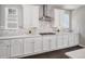 Bright, modern kitchen with white cabinets, marble backsplash, stainless steel appliances, and hardwood floors at 3453 Pacific Peak Dr, Broomfield, CO 80023