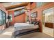 Comfortable bedroom with vaulted ceiling, exposed beams, and an en-suite bathroom at 7282 Silverhorn Dr, Evergreen, CO 80439