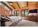 Cozy bedroom featuring large windows with wooded views, vaulted ceiling, and a ceiling fan at 7282 Silverhorn Dr, Evergreen, CO 80439