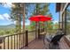 Spacious wooden deck with black railing and seating that overlooks a mountain view at 7282 Silverhorn Dr, Evergreen, CO 80439